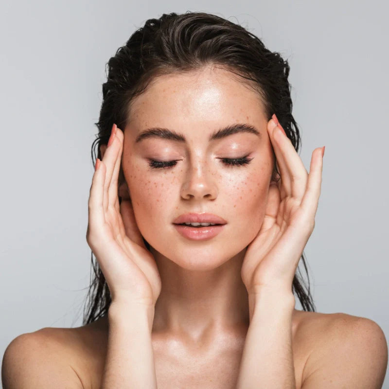 en vakker kvinne som holder på ansiktet sitt 